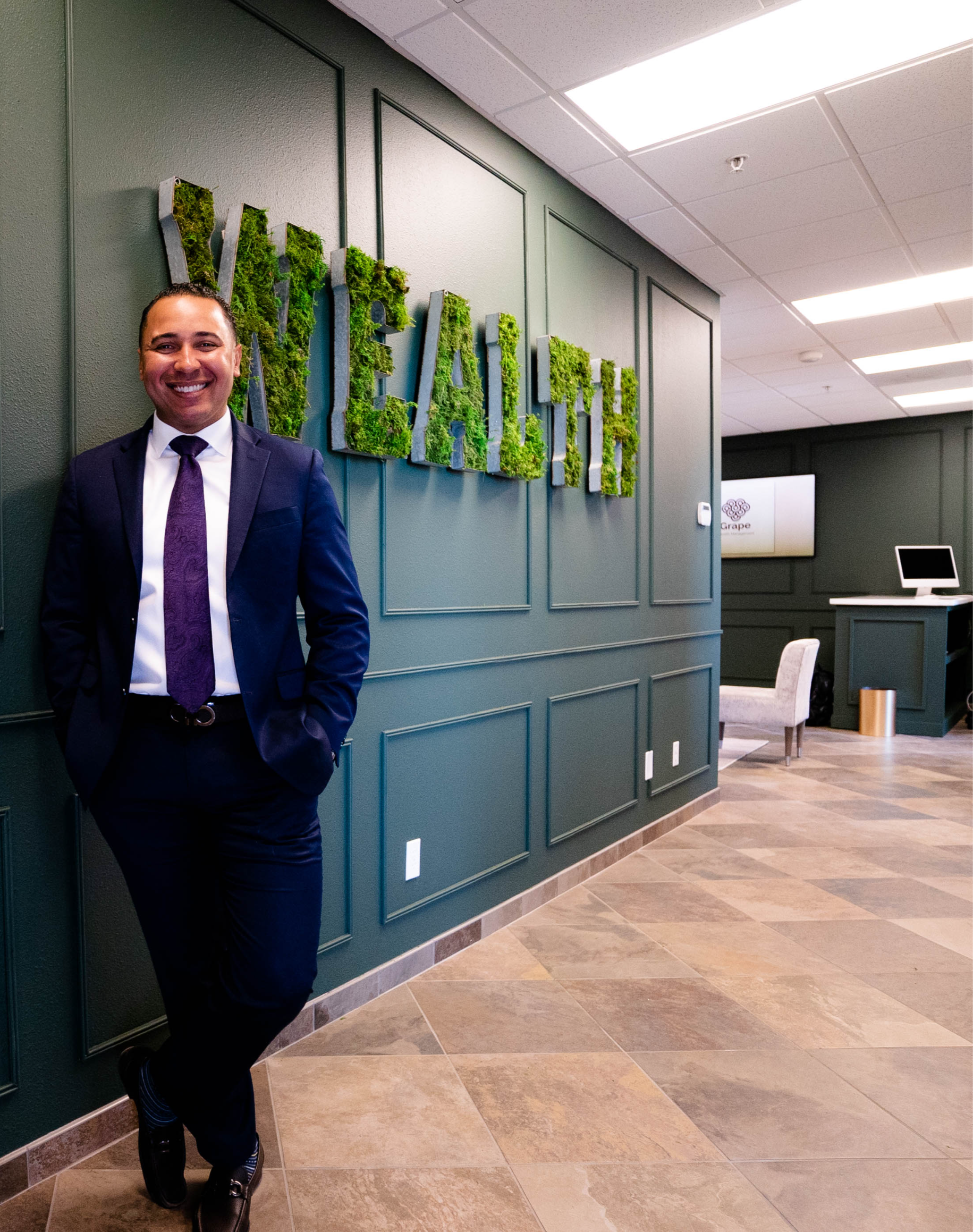 Alexander Newman standing in the Grape Wealth Management office